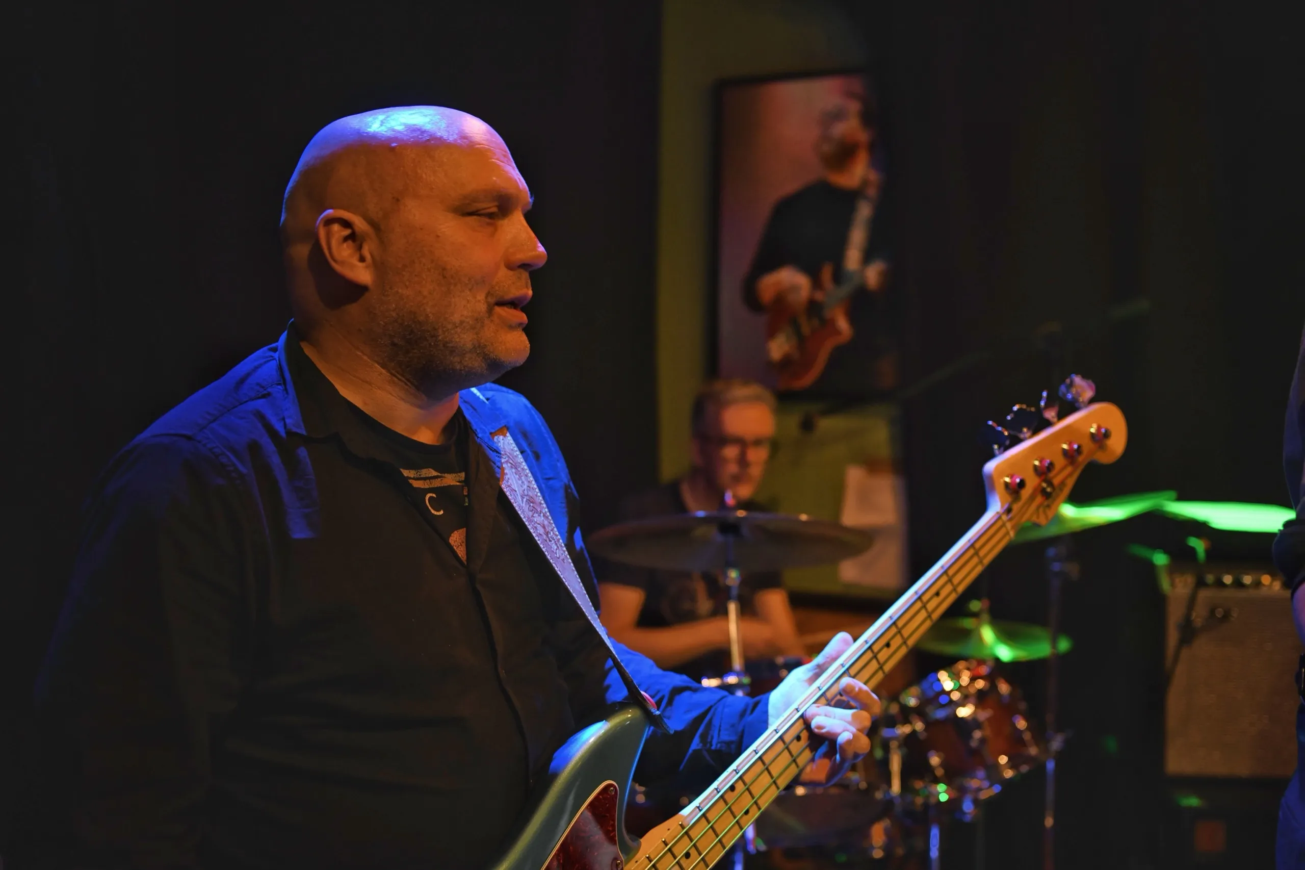 Bassist in profiel, blauw podiumlicht